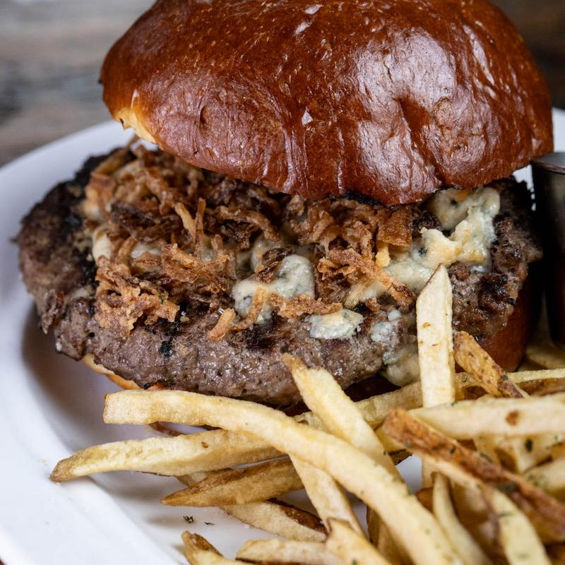 Burger with blue cheese, crispy onions and herb fries at Harper's